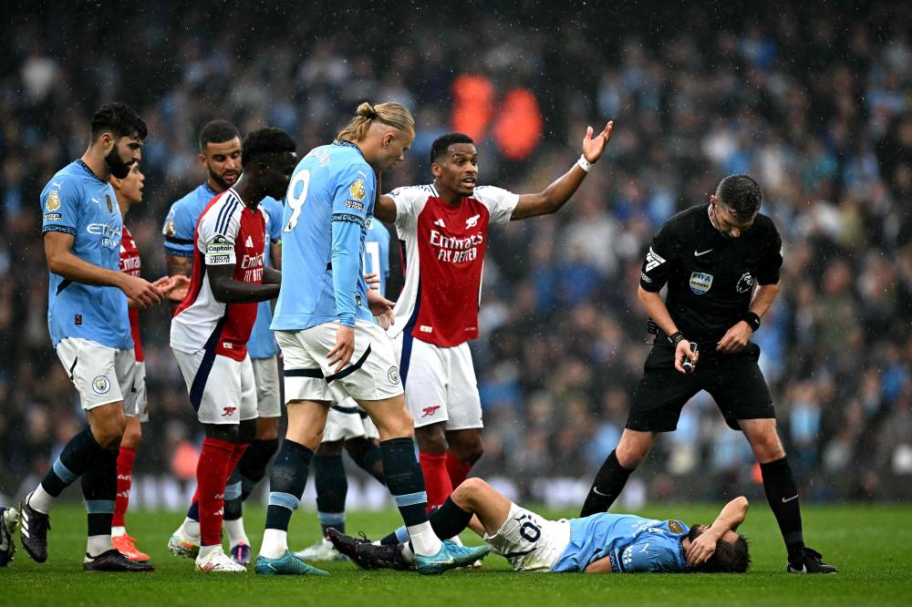 Manchester City's Portuguese midfielder Bernardo Silva reacts on the ground after being fouled by Arsenal's Belgian midfielder Leandro Trossard during the English Premier League football match between Manchester City and Arsenal at the Etihad Stadium in Manchester, north west England, on September 22, 2024. (Photo by Paul ELLIS AFP)