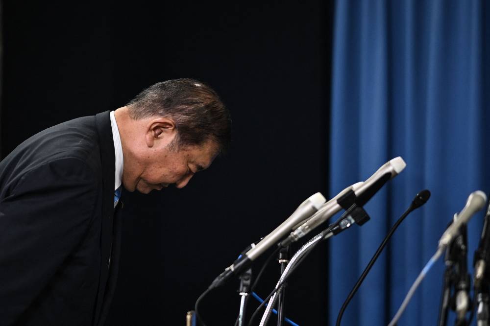 Shigeru Ishiba, the new head of the ruling Liberal Democratic Party (LDP), bows toward the Japanese flag as he walks to the podium to speak at a press conference at the party's headquarters in Tokyo on September 30, 2024. - Photo by AFP