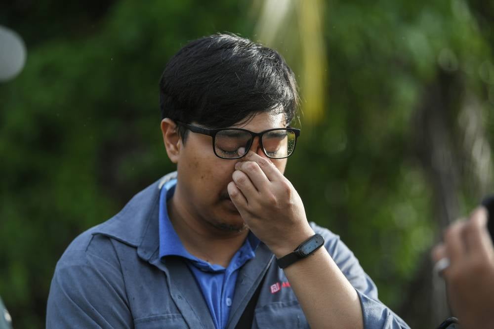 Amir Hakimi Sabari, 25, arrived at the site of the search for his father, who was killed before being thrown into the Padang Terap River in Jitra. Photo by Bernama