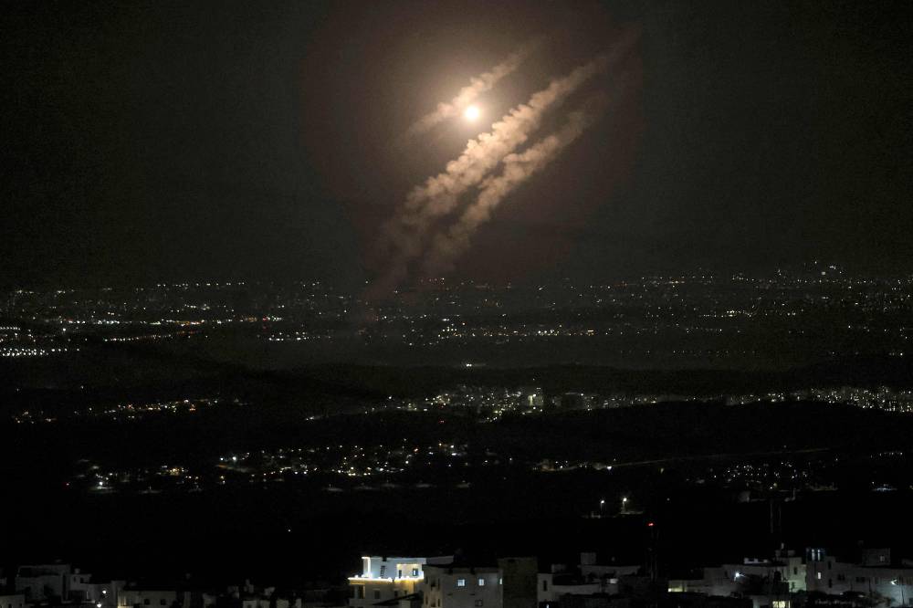 This picture taken from the West Bank city of Hebron shows projectiles above the Israeli city of Ashdod on October 1, 2024. Iran's Revolutionary Guards said a missile attack under way against Israel on October 1 was in response to the killing of Hezbollah chief Hassan Nasrallah last week as well as that of the Hamas leader. (Photo by AFP)