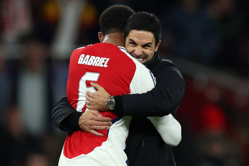 Arsenal's Spanish manager Mikel Arteta celebrates with Arsenal's Brazilian defender #06 Gabriel Magalhaes during the UEFA Champions League football match between Arsenal and Paris Saint-Germain (PSG) at the Emirates Stadium in north London on October 1, 2024. Arsenal won the match 2-0. (Photo by AFP)
