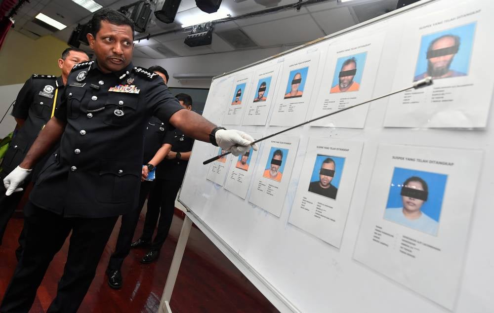 Hussein points a photo of the suspect arrested during a press conference at the Selangor Police Contingent Headquarters today. The briefing highlighted the police's success in dismantling a robbery case in Pandamaran and a burglary case involving foreign nationals. - Photo by Bernama