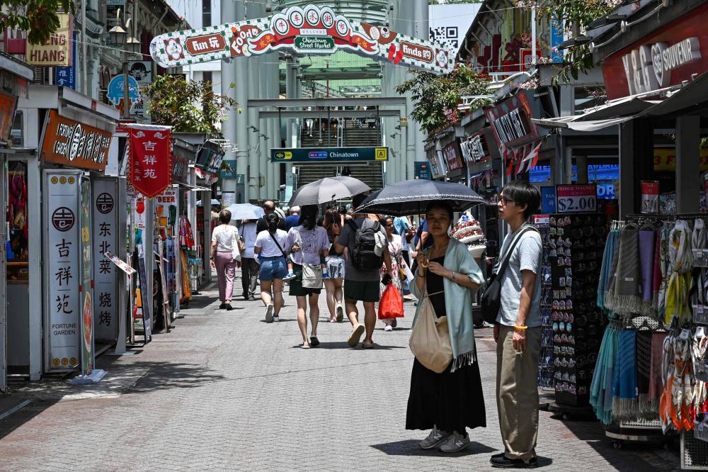 People walk along a pedestrian street in the Chinatown district of Singapore on October 7, 2024. (Photo by AFP)