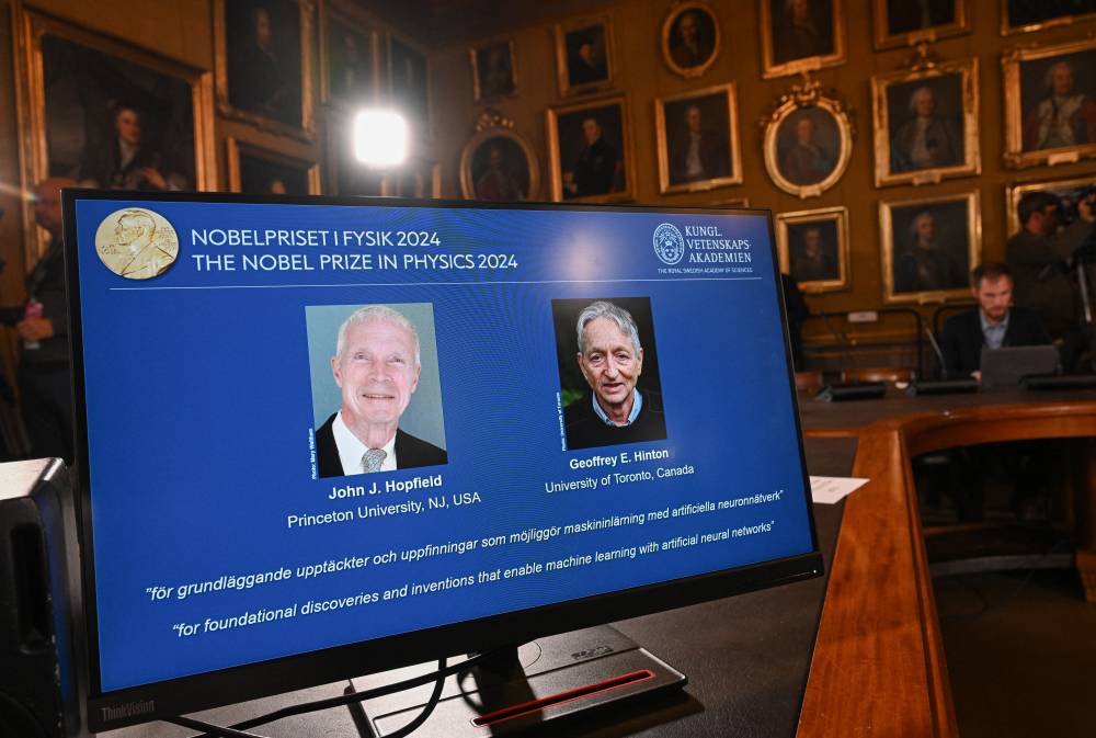 A screen shows the laureats of the 2024 Nobel Prize in Physics, US physicist John J Hopfield and Canadian-British computer scientist and cognitive psychologist Geoffrey E Hinton, during the announcement by the Royal Swedish Academy of Sciences in Stockholm, Sweden on Oct 8, 2024. - (Photo by JONATHAN NACKSTRAND / AFP)