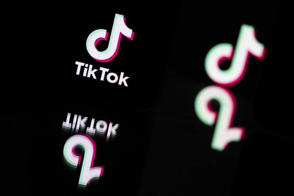 This photograph taken in Mulhouse, eastern France on Oct 19, 2023, shows the logo of the social media video sharing app TikTok reflected in mirrors. - (Photo by SEBASTIEN BOZON / AFP)