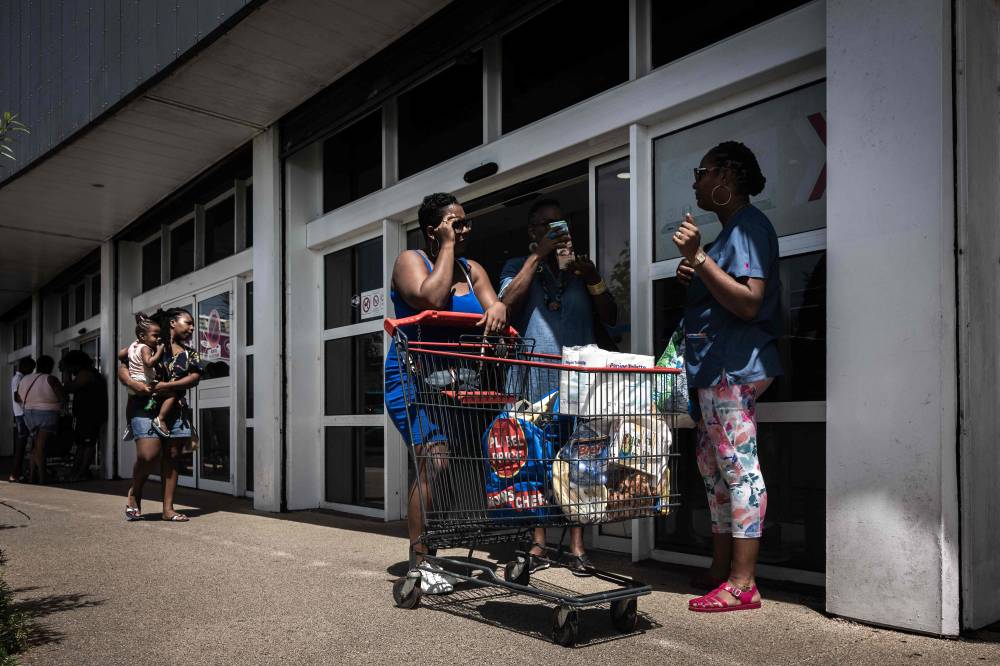 People chat after shopping at a supermarket in Fort-de-France, on the French Caribbean island of Martinique on October 14, 2024, amid riots over rising prices. - Photo by AFP