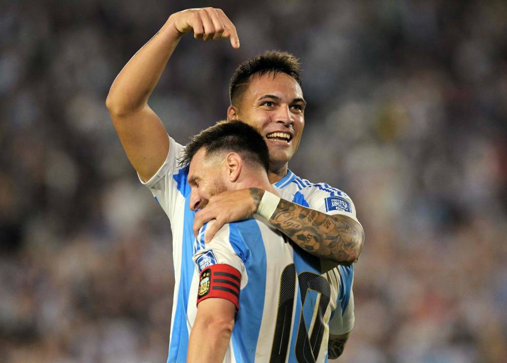 Argentina's forward Lautaro Martinez celebrates with Argentina's forward Lionel Messi after scoring during the 2026 FIFA World Cup South American qualifiers football match between Argentina and Bolivia at the Mas Monumental stadium in Buenos Aires on October 15, 2024. (Photo by AFP)
