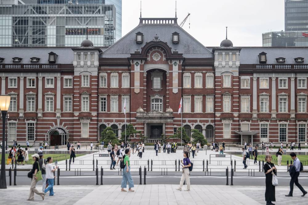 This picture taken on July 25, 2024 shows people walking past Tokyo station in Tokyo.- (Photo by YUICHI YAMAZAKI / AFP)