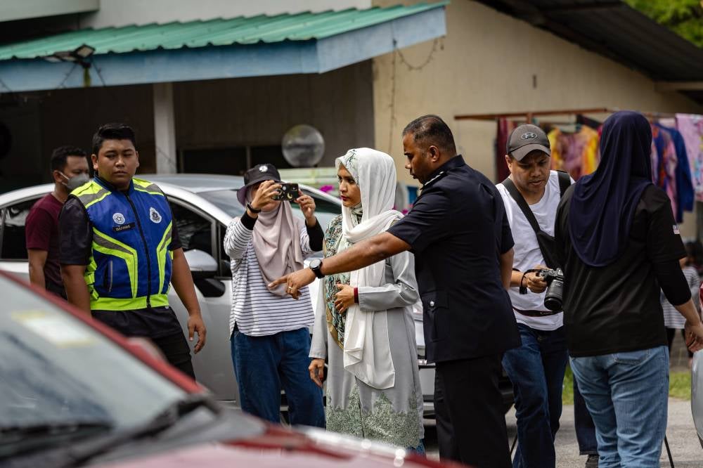Ummu Atiyah, who is the eldest daughter of the Al-Arqam leader also known as Abuya, was taken to the scene of the incident at 2.38pm escorted by five police vehicles from the Taiping district police headquarters. Photo by Bernama