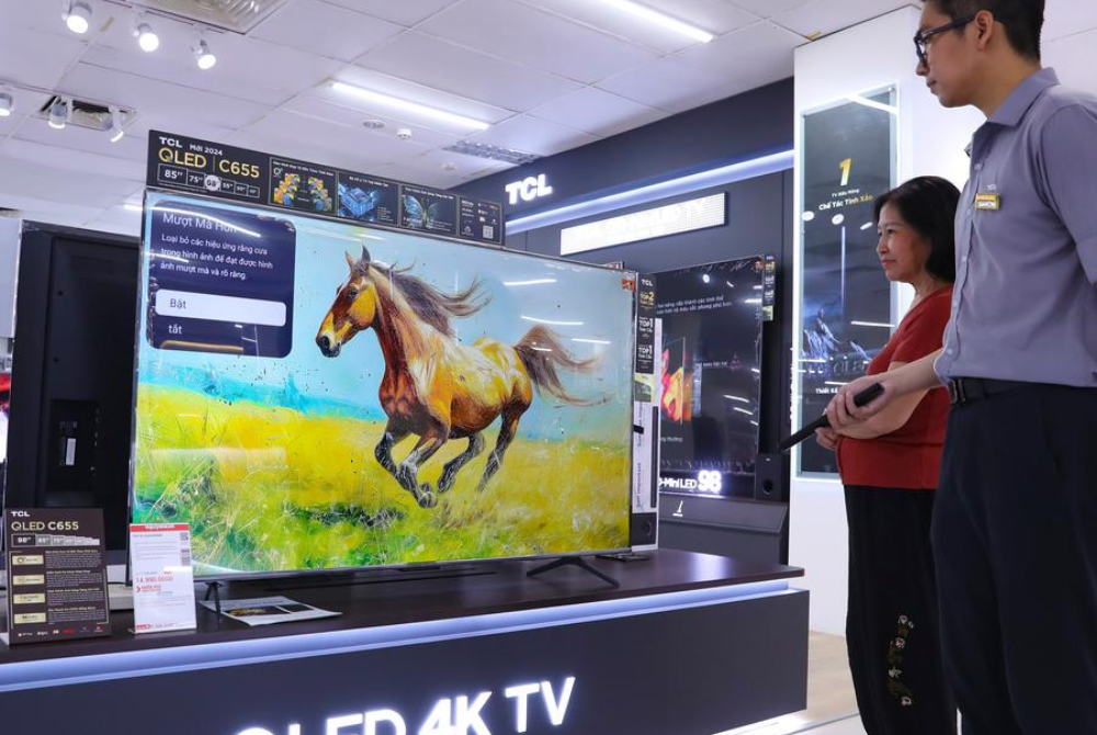A salesperson introduces the performance of TCL TV sets to a customer at a store in Hanoi, Vietnam, Oct. 11, 2024. (Photo by Xinhua)
