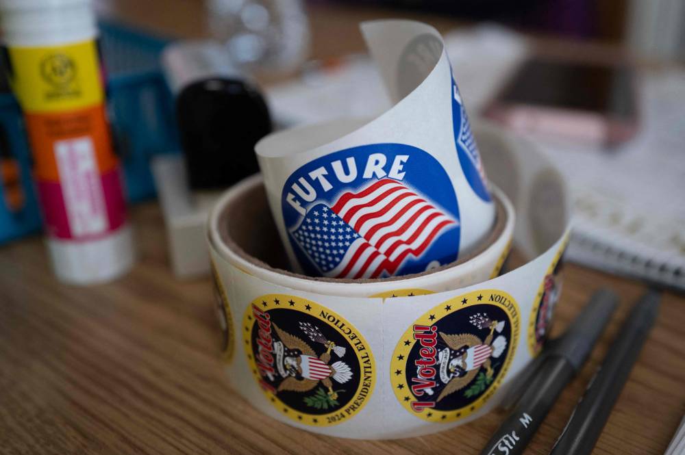 Stickers given to voters sit on a table at the Kenosha Municipal Building where an election official collects mail-in ballots from residents on October 21, 2024 in Kenosha, Wisconsin. In-person early voting begins across the state tomorrow. (Photo by SCOTT OLSON / AFP)