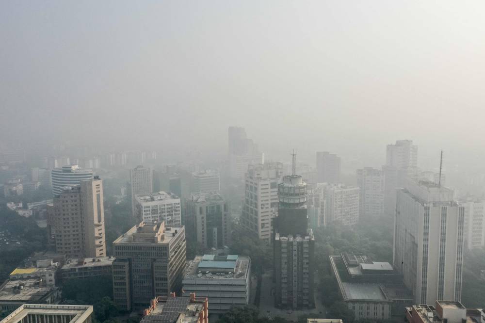 Thick smog engulfs the city skyline in New Delhi on October 23, 2024. Acrid clouds enveloped India's capital on October 23, as air pollution fuelled by fireworks and farm stubble burning was ranked "hazardous" by monitors for the first time this winter. (Photo by Shubham KOUL / AFP)