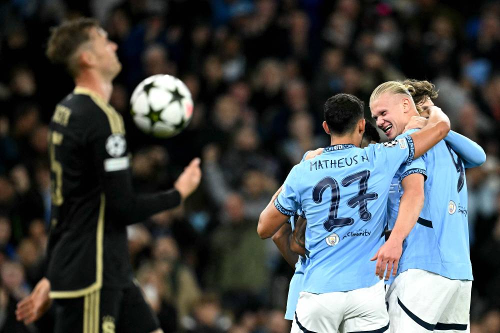 Manchester City's Norwegian striker Erling Haaland (R) celebrates scoring the team's second goal with Manchester City's Portuguese midfielder #27 Matheus Nunes during the UEFA Champions League football match between Manchester City and Sparta Prague at the Etihad Stadium in Manchester, north west England, on October 23, 2024. (Photo by Oli SCARFF / AFP)
