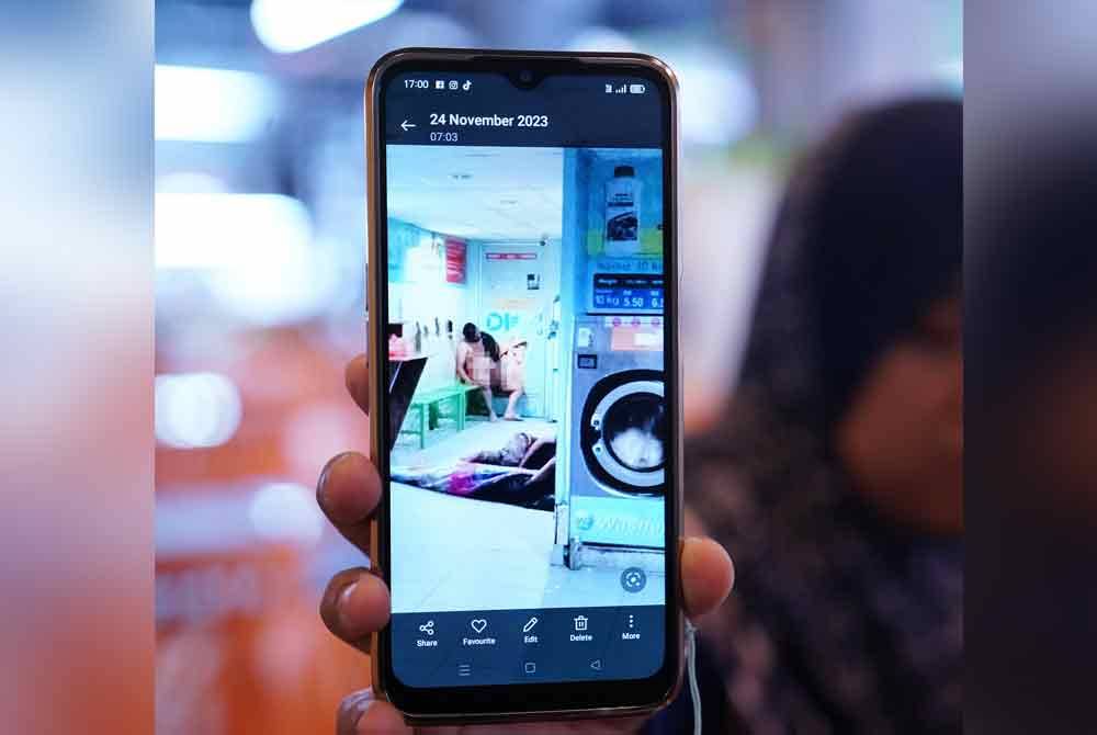 A local resident shows a photo of a drunk foreigner sleeping naked at the Pandan Mewah flats in Ampang.
