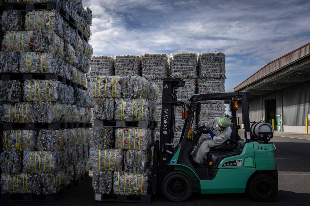 A worker on a forklift moving a bale of plastic bottle at the recycling factory 'Japantech East Japan PET Bottle MR Center' in Kasama city of Ibaraki prefecture. Photo by Yuichi Yamazaki/ AFP
