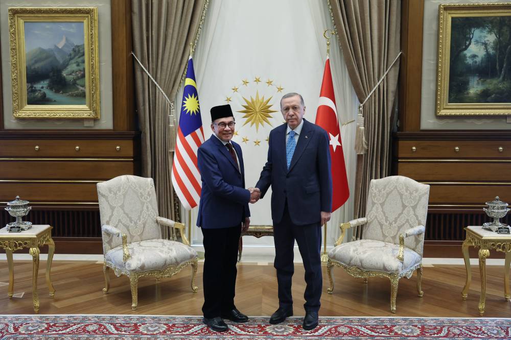This handout photograph taken and release on Feb 15, 2023 shows Turkish President Recep Tayyip Erdogan (right) and Malaysian Prime Minister Datuk Seri Anwar Ibrahim (left) posing during their meeting at the presidential complex in Ankara. AFP FILE PIX