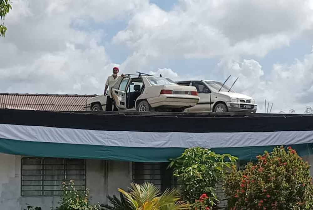 Awang with his two cars temporarily parked on the roof of his house in Kampung Matang Bonglai Kechil, Ayer Hitam.