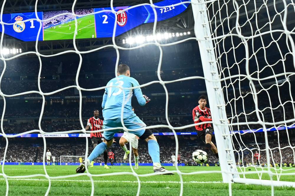 AC Milan's Dutch midfielder Tijani Reijnders scores a goal past Real Madrid's Ukrainian goalkeeper Andriy Lunin during the UEFA Champions League, league phase day 4 football match between Real Madrid CF and AC Milan at the Santiago Bernabeu stadium in Madrid on November 5, 2024. (Photo by OSCAR DEL POZO / AFP)