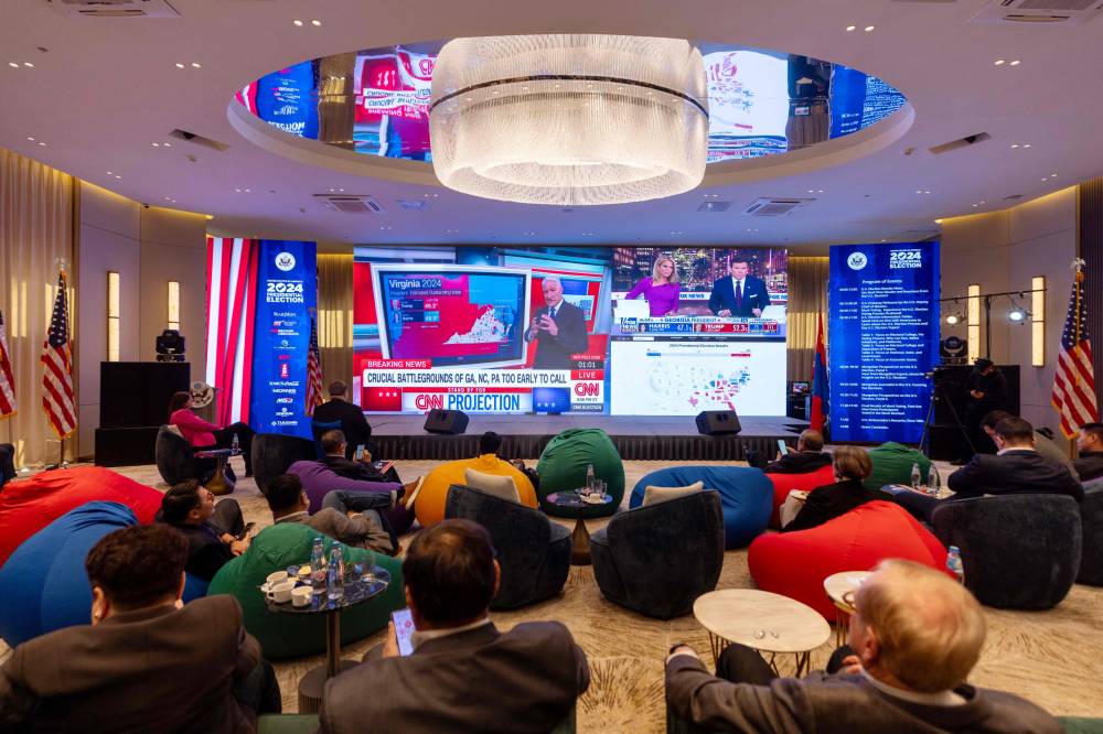 People watch television coverage of the US election, at an event organised by the US embassy, in Ulaanbaatar, the capital of Mongolia on November 6, 2024. - Photo by AFP