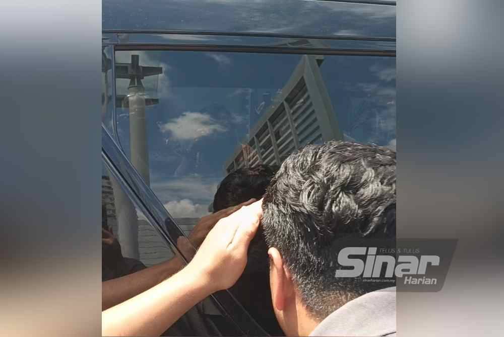 A photographer tried to see through the tinted windows of the Toyota Vellfire to get a glimpse of Vivy and Fadzarudin. - Photo SINAR/HISYAMUDDIN AYUB