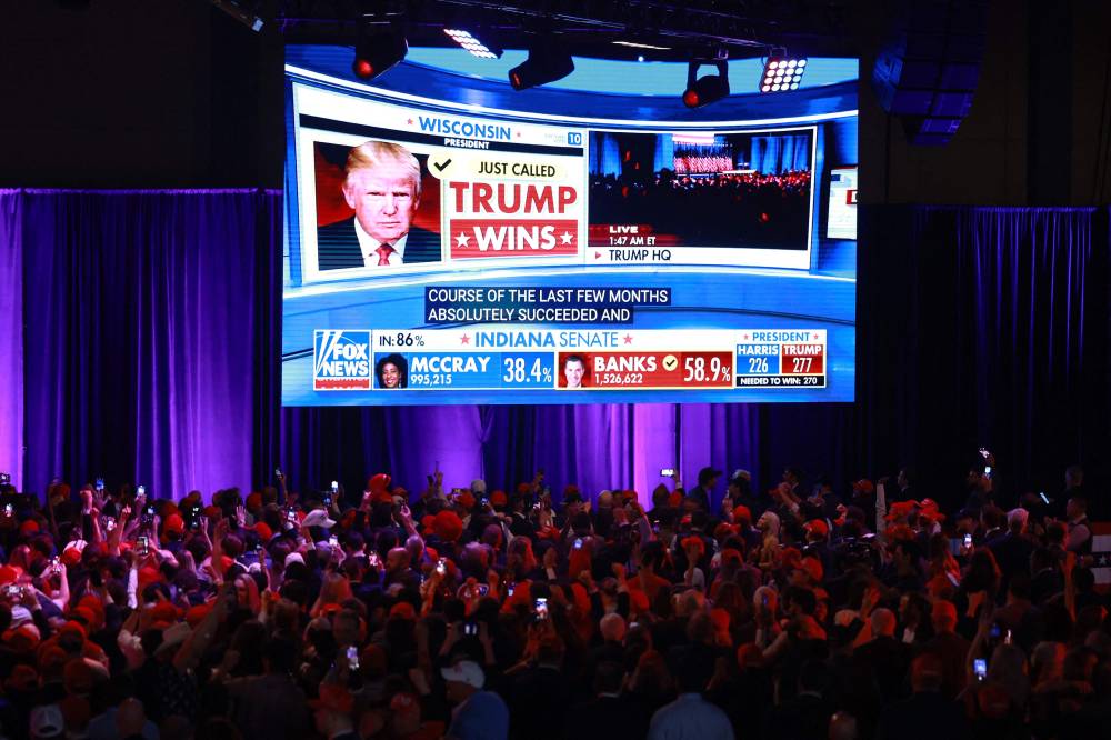 Supporters take photos as Fox News projects Republican presidential nominee, former US President Donald Trump is elected president during an election night event at the Palm Beach Convention Centre on November 06, 2024 in West Palm Beach, Florida. - Photo by AFP