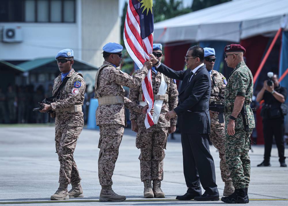 Defence Minister Datuk Seri Mohamed Khaled Nordin handing over the Malaysian flag to MALBATT 850-12 Commander Col Johan Effendi Mohd Shalleh during the sending-off ceremony for the first batch of MALBATT 850-12 to Lebanon at the Subang Air Base today. - Photo by Bernama