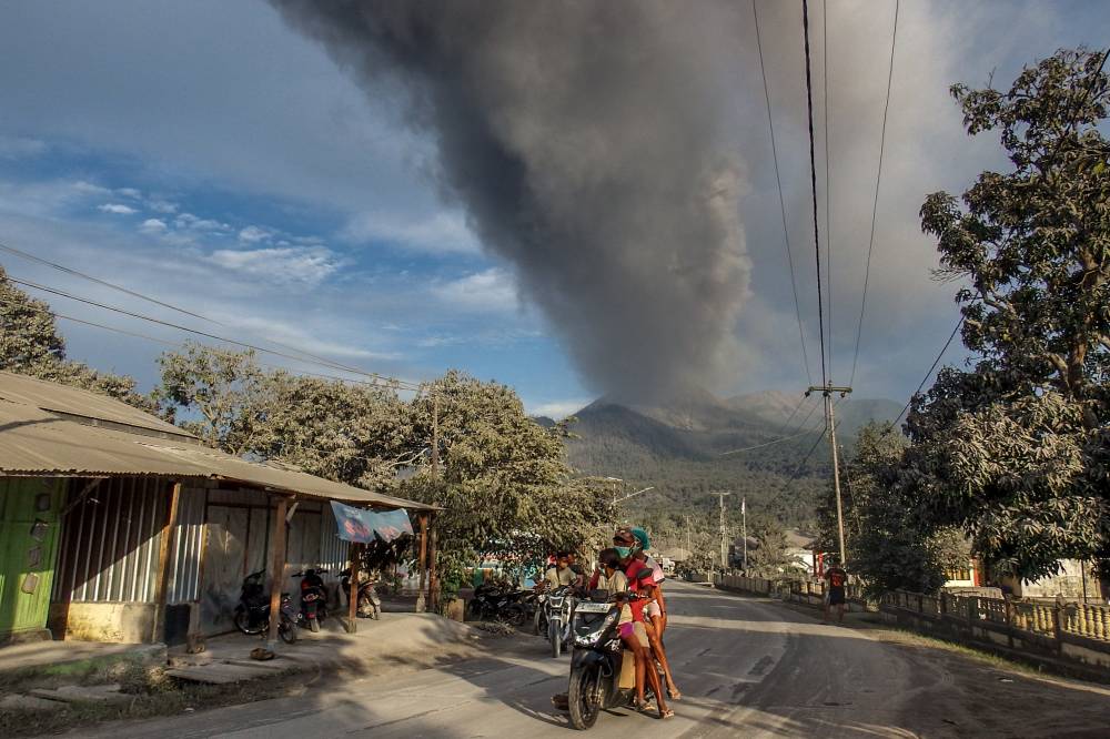Villagers flee during an eruption of Mount Lewotobi Laki-Laki, a day after the previous eruption, in Boru Village, in East Flores, East Nusa Tenggara, on November 5, 2024. (Photo by ARNOLD WELIANTO / AFP)