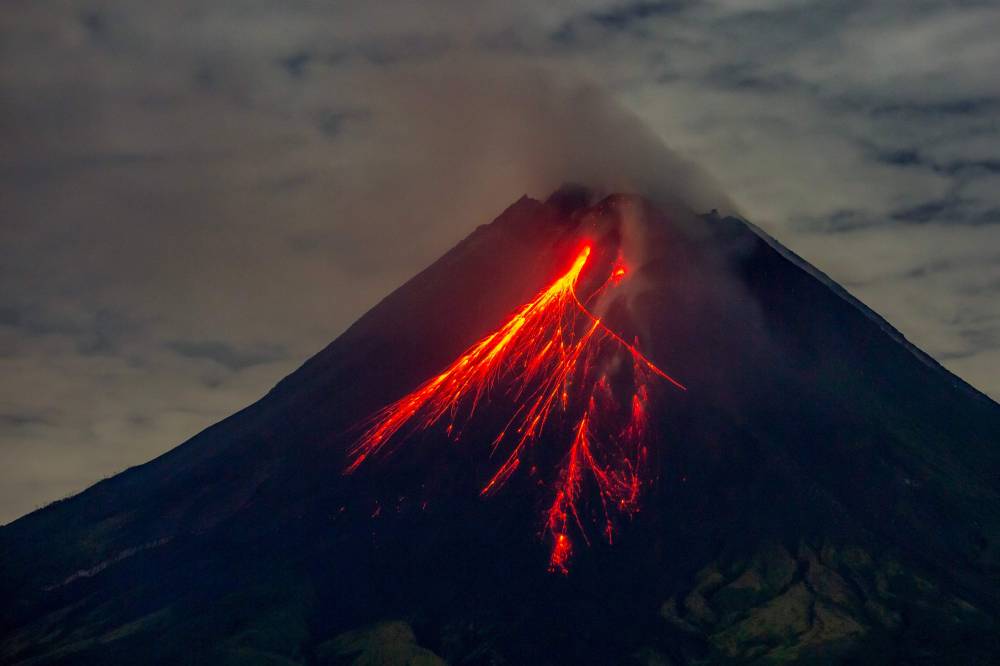 Mount Merapi spews lava onto its slopes during an eruption as seen from Srumbung village in Magelang, Central Java, on November 4, 2024. (Photo by DEVI RAHMAN / AFP)