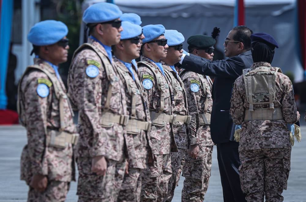 Defence Minister Datuk Seri Mohamed Khaled Nordin placing the beret on MALBATT 850-12 officers, led by Col Johan Effendi Mohd Shalleh, during the sending-off ceremony for the first batch of MALBATT 850-12 to Lebanon at the Subang Air Base yesterday. - Photo by Bernama