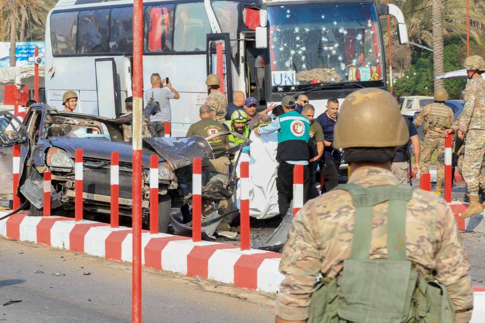 First aid responders and Lebanese army soldiers gather at the site of an Israeli strike on a car at the northern entrance of the southern city of Sidon, on Nov 7, 2024. - (Photo by MAHMOUD ZAYYAT / AFP)
