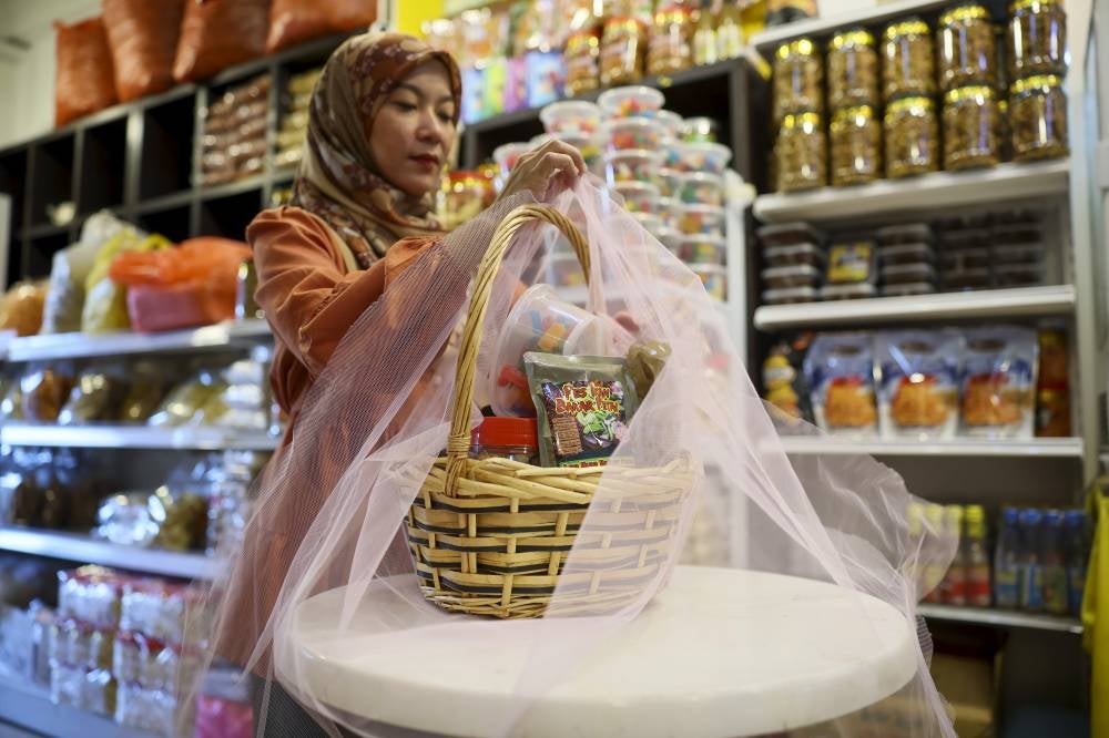 Business owner Siti Sulekha Zakaria, 36, prepares a hamper filled with food products synonymous with the state of Tok Gajah at her shop in Kompleks Serambi Teruntum recently. Photo by Bernama