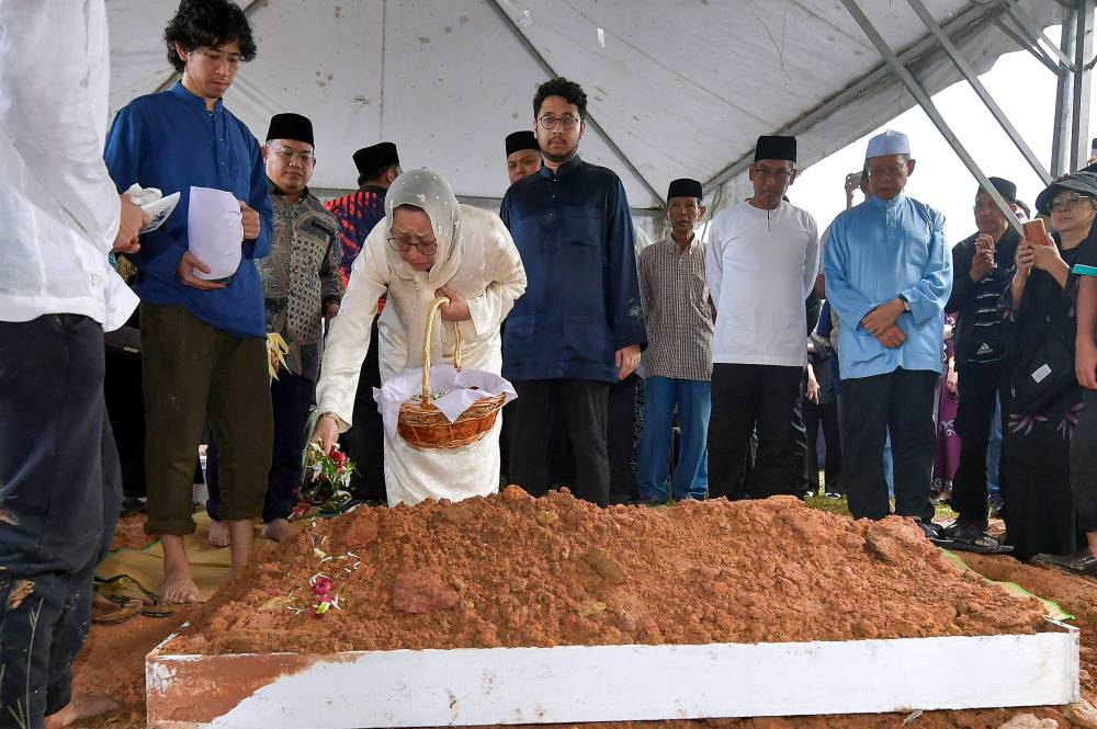 Toh Puan Na’imah Abdul Khalid, wife of former finance minister Tun Daim Zainuddin, sprinkled rose water over her late husband’s grave at the Bukit Kiara Cemetery 1 this afternoon. Photo by Bernama