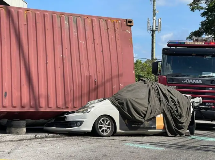 A woman driver was killed while another driver was seriously hurt when a container being transported on a trailer lorry toppled and crushed them in an accident involving five vehicles in Jalan Bukit Tengah here yesterday.