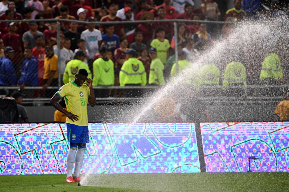Brazil's forward #21 Luiz Henrique stands next to a water sprinkler during the 2026 FIFA World Cup South American qualifiers football match between Venezuela and Brazil at the Monumental stadium in Maturin, Monagas State, Venezuela, on November 14, 2024. (Photo by Federico Parra / AFP)
