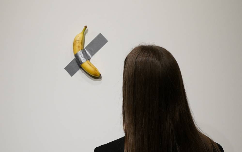 People look at Italian visual artist Maurizio Cattelan's duct-taped Banana entitled "Comedian'. Photo by Timothy A. Clary/AFP