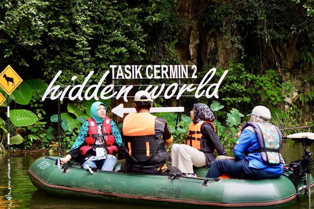 A journey through a shadowy 130-meter water tunnel by boat leads you to the serene beauty of Tasik Cermin 2. Photo: Islamic Tourism Centre