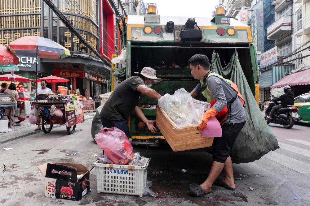 Dustmen collect plastic garbage left by the roadside in Bangkok on September 10, 2024. (Photo by Chanakarn Laosarakham / AFP)