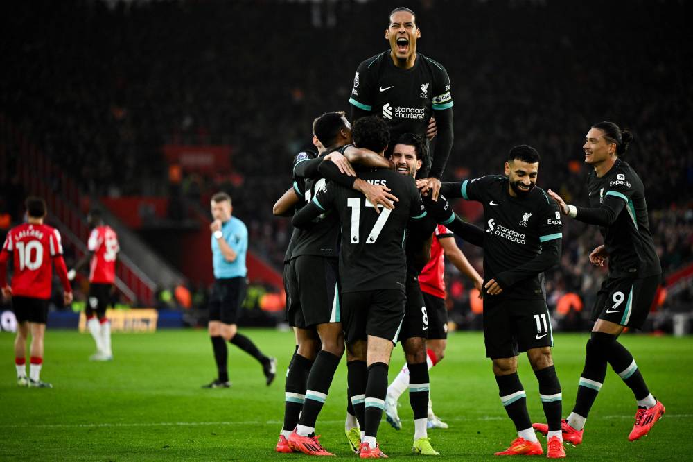Liverpool's Hungarian midfielder Dominik Szoboszlai (C) celebrates with teammates after scoring his team first goal during the English Premier League football match between Southampton and Liverpool at St Mary's Stadium in Southampton, southern England on November 24, 2024. (Photo by JUSTIN TALLIS / AFP)