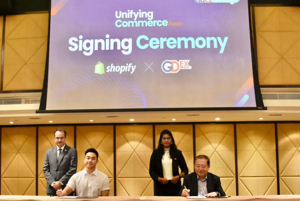 (Seated from left) Shopify Inc Head of Business Development for Southeast Asia Frankie Ng
and GDEX Berhad Managing Director/Group CEO Teong Teck Lean signing the partnership
agreement, witnessed by (standing from left) High Commission of Canada in Kuala Lumpur
Counsellor (Trade) and Senior Trade Commissioner Eric Pelletier and Trade Commissioner
Naneecharam Muniandy.