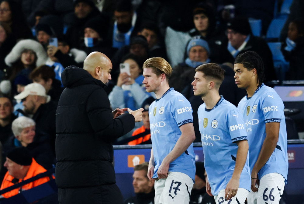 Manchester City's Spanish manager Pep Guardiola (L) speaks to (from L) Manchester City's Belgian midfielder Kevin De Bruyne, Manchester City's English midfielder James McAtee and Manchester City's English defender Jahmai Simpson-Pusey during the UEFA Champions League football match between Manchester City and Feyenoord at the Etihad Stadium in Manchester, north west England, on November 26, 2024. (Photo by Darren Staples / AFP)