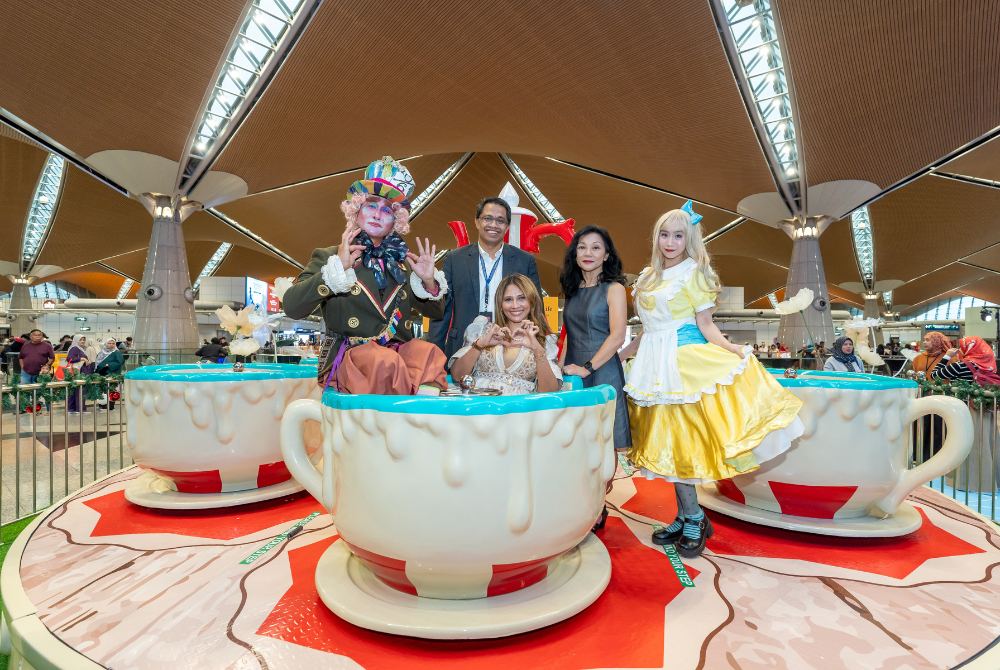 Zulhikam Ahmad, General Manager of Commercial Services at Malaysia Airports Holdings Berhad; Hani Ezra Hussin, Senior General Manager of Commercial Services at Malaysia Airports Holdings Berhad; and Wong Lapkeng, Head of Asia Pacific for ArtiStory photographed on the Gigantic Tea-Cup ride along with characters like Alice and The Mad Hatter - Photo courtesy of Malaysia Airports
