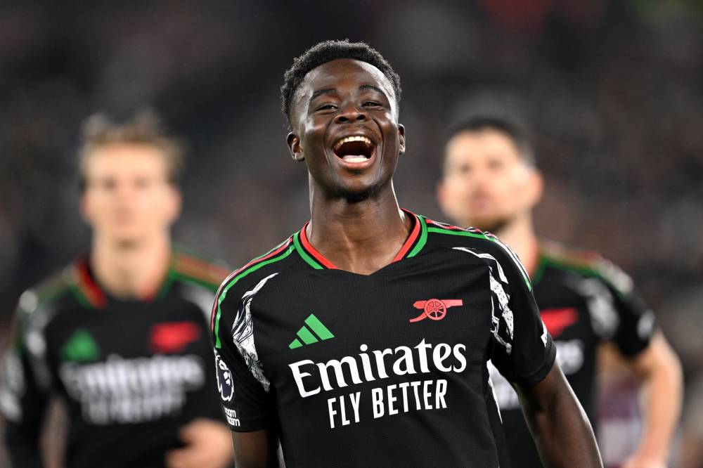 Bukayo Saka of Arsenal celebrates scoring his team's fifth goal from a penalty kick during the Premier League match between West Ham United FC and Arsenal FC at London Stadium on November 30, 2024 in London, England. (Photo by David Price/Arsenal FC via Getty Images)
