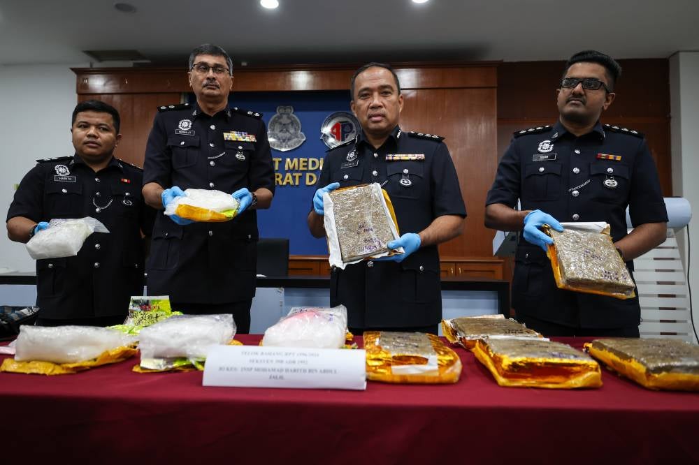 Sazalee (second from right) shows the drugs seized from the suspect at a jetty in Teluk Bahang. - Photo by Bernama
