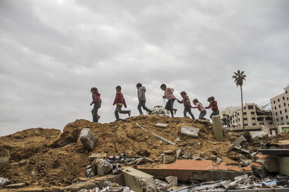 Palestinian children walk on the rubble in Gaza City, Nov 28, 2024. - (Photo by Mahmoud Zaki / XINHUA)