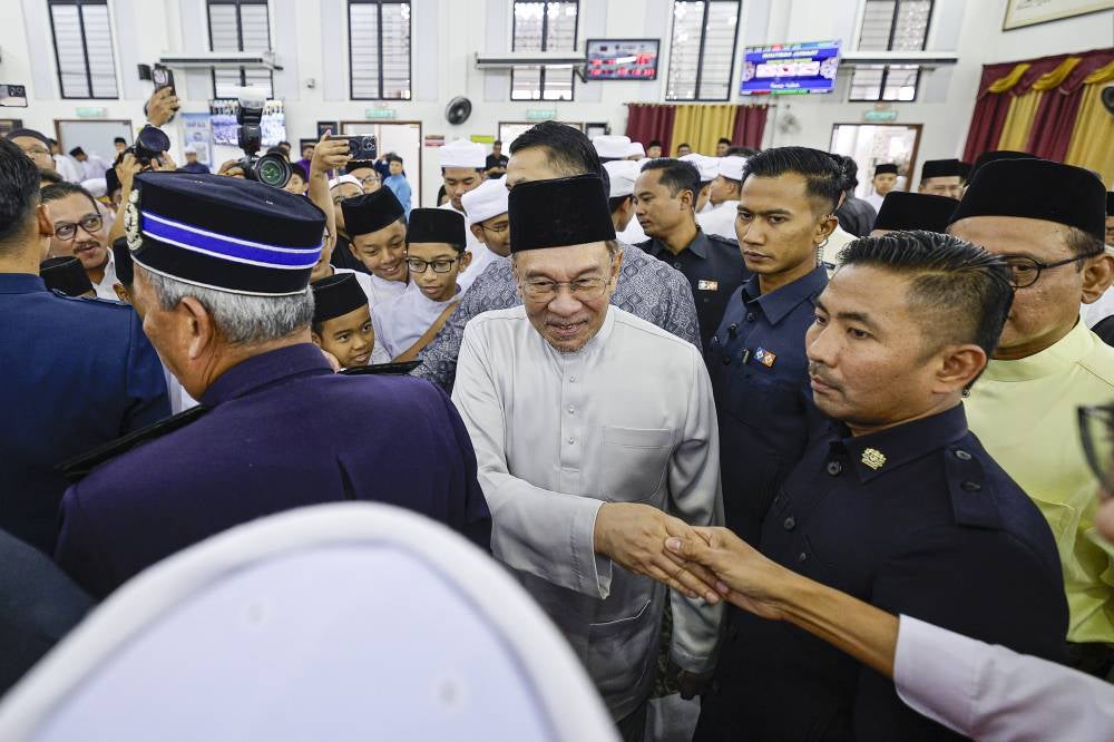 Anwar after performing Friday prayers at Surau Darul Ulum, Sekolah Menengah Kebangsaan Agama (SMKA) Putrajaya, Presint 11, today. Photo by Bernama
