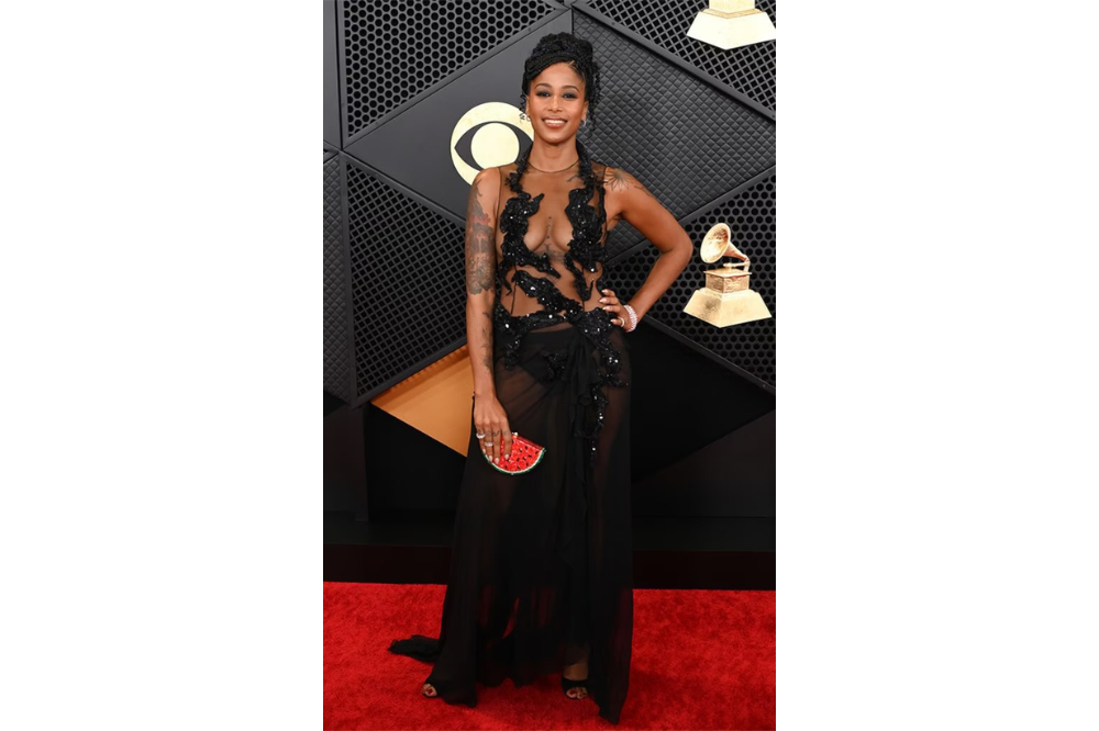 Aja Monet holding a watermelon clutch to communicate solidarity with Palestine.