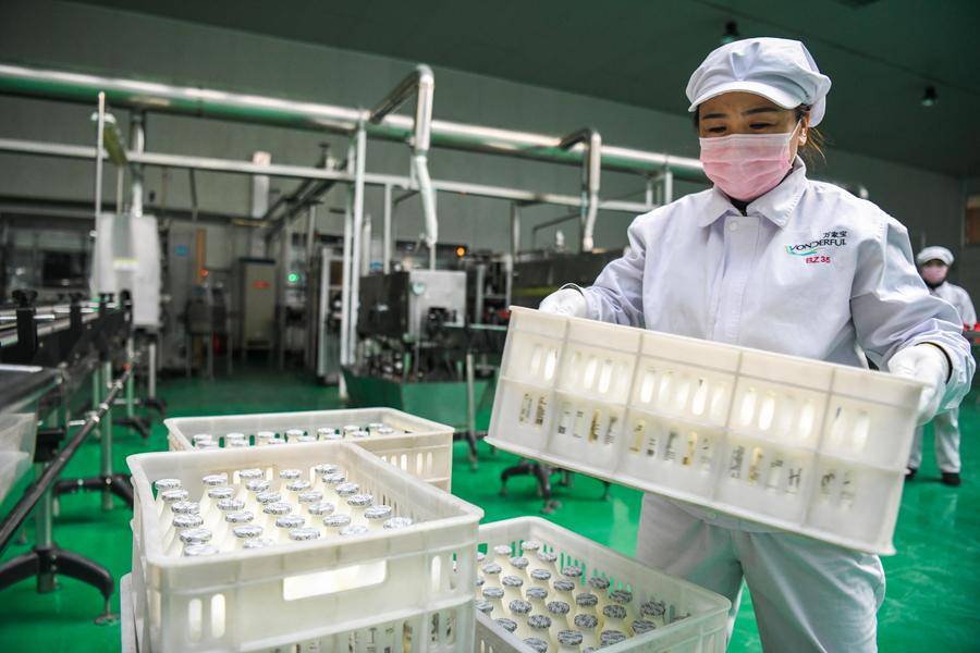 Staff working at the workshop of a milk production company in Harbin, northeast China's Heilongjiang Province, March 2, 2020. - (Photo by Wang Song / XINHUA)