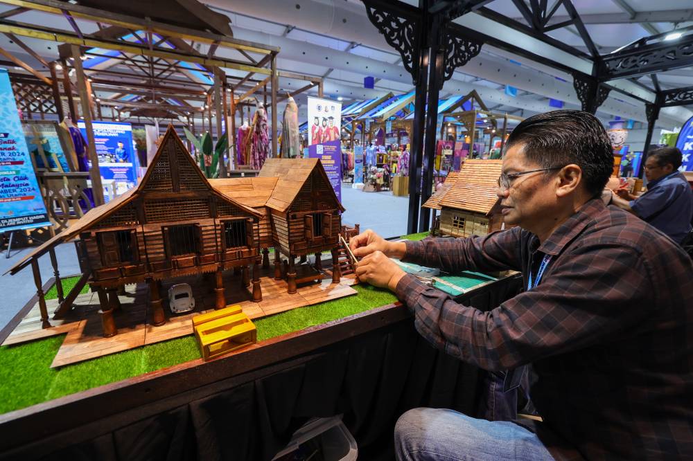 A craft entrepreneur specialising in traditional Malay house replicas, Mohd Amin Afuan, 58, showcases a replica of a Johor house during an interview with Bernama at the Johor Craft Festival and the 2024 Kota Selatan Festival at Angsana Johor Bahru. - Photo by Bernama