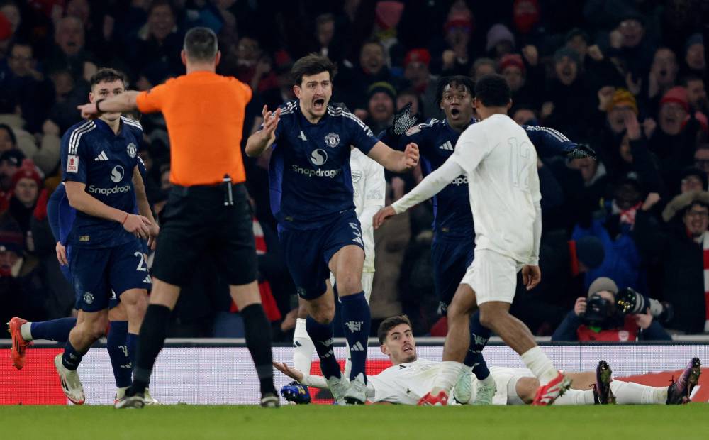 Referee Andy Madley points to the spot as he awards a penalty to Arsenal after Manchester United's English defender Harry Maguire fouled Arsenal's German midfielder Kai Havertz during the English FA Cup third round football match between Arsenal and Manchester United at the Emirates Stadium in London on January 12, 2025. (Photo by Ian Kington/AFP)