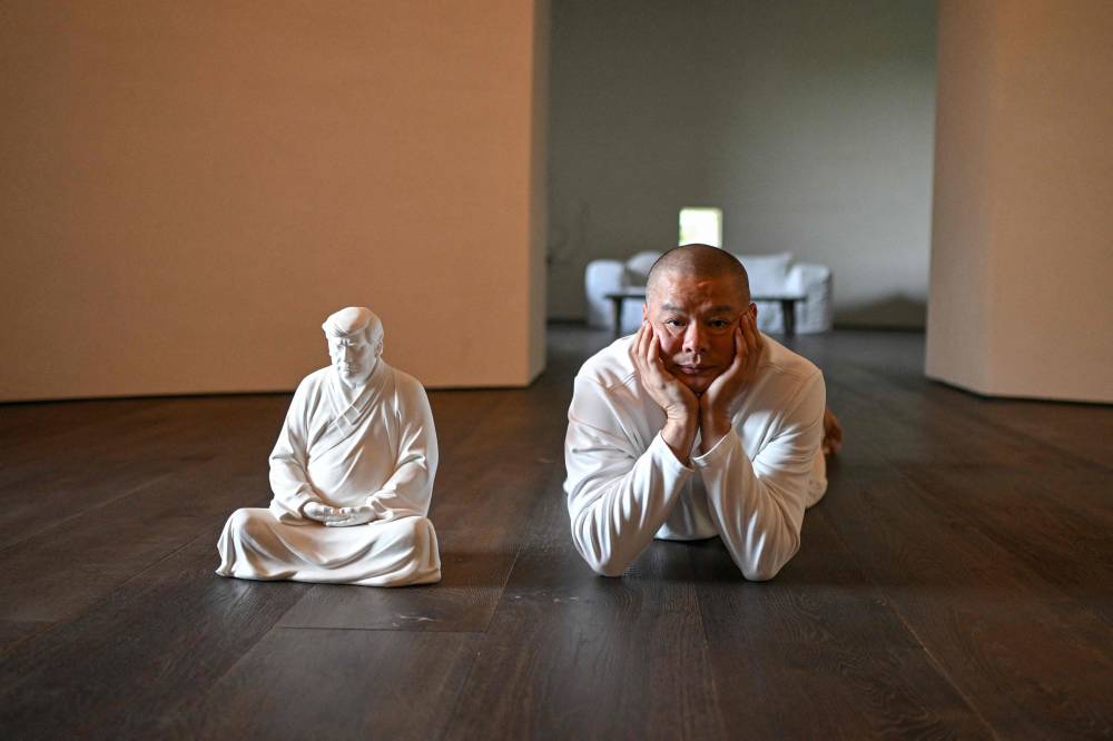 Donald Trump is not typically known for his calm or reserve, but in a craftsman's workshop in rural China, the US president-elect sits in divine contemplation. (Photo by Jade GAO/AFP) 